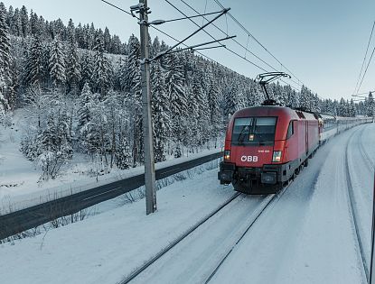 roter-zug-der-oebb-faehrt-im-winter-durch-schnee-auf-den-schienen-1